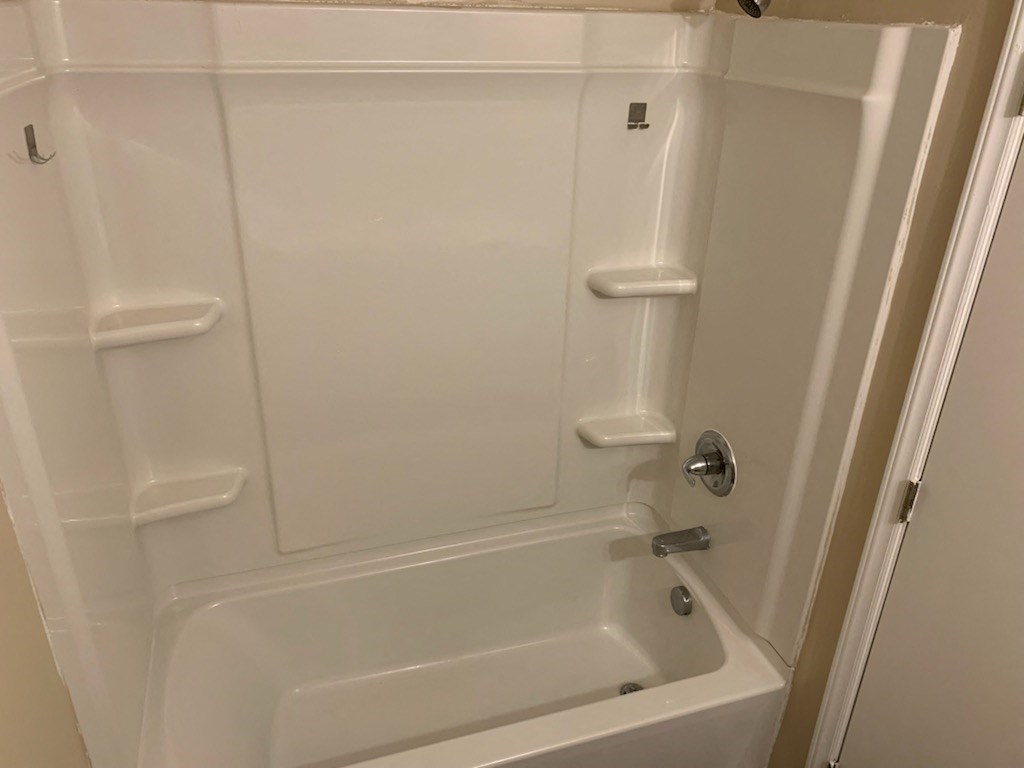White bathtub with shelfs