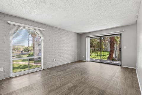 A room with a white brick wall and wooden flooring.