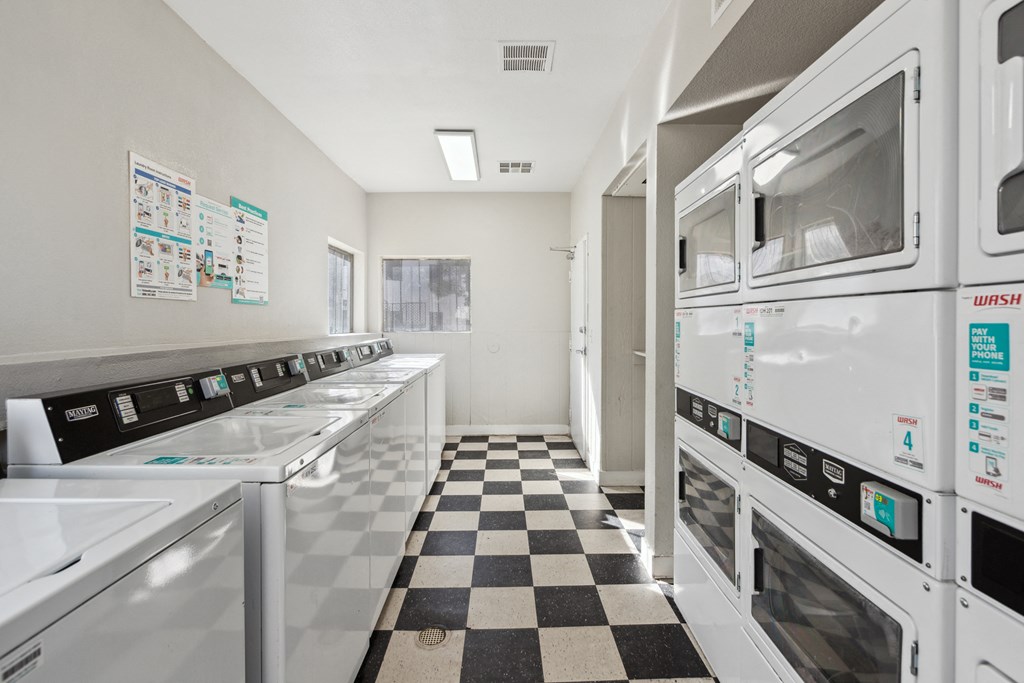 a kitchen with white appliances and a checkered floor