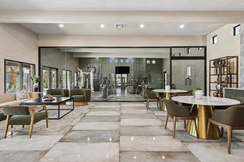 A modern dining room with a glass wall and a large table.