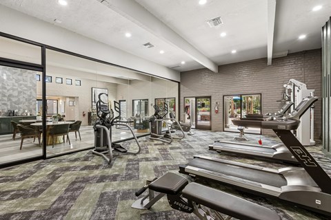 A gym with treadmills, weights, and exercise equipment.