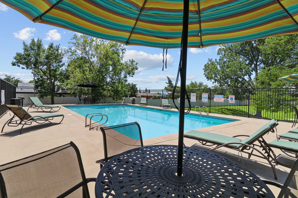 our apartments have a swimming pool with chairs and umbrellas