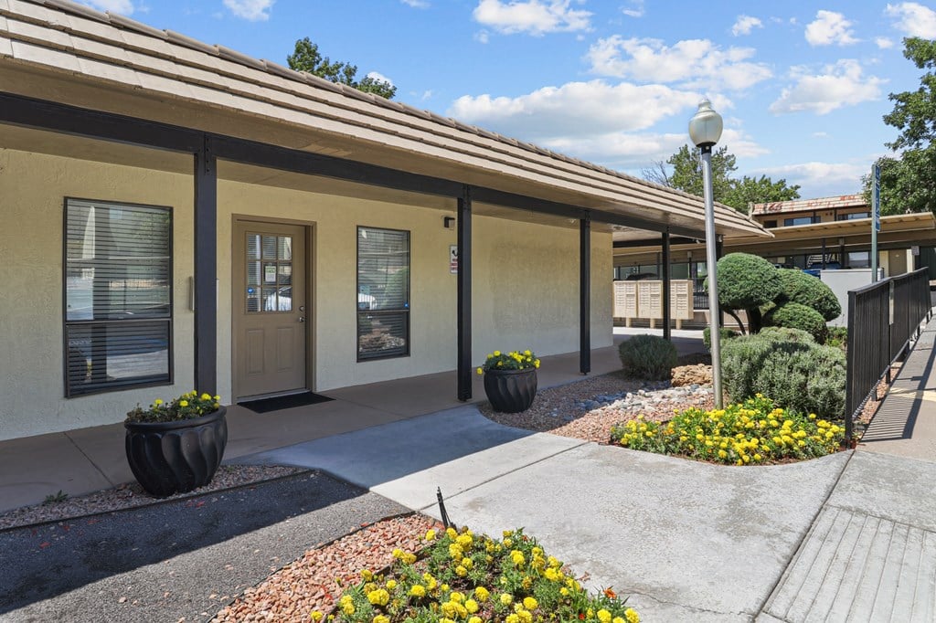 a walkway in front of a building with a sidewalk and plants