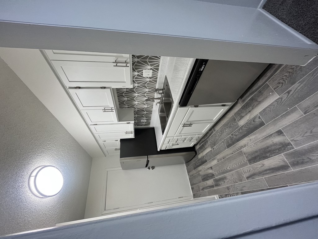 the view from above of a small bathroom with a mirror and a gray and white