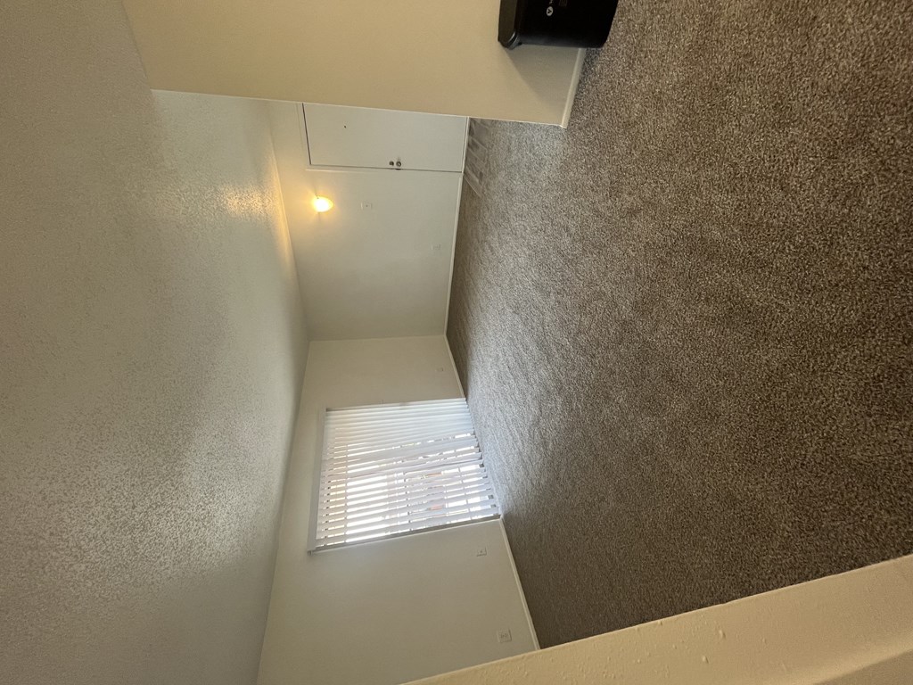 the view from the bottom of a stairwell looking up to a window