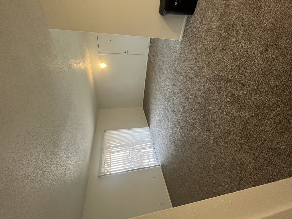 the view from the bottom of a stairwell looking up to a window