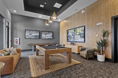 A room with a pool table and a couch.