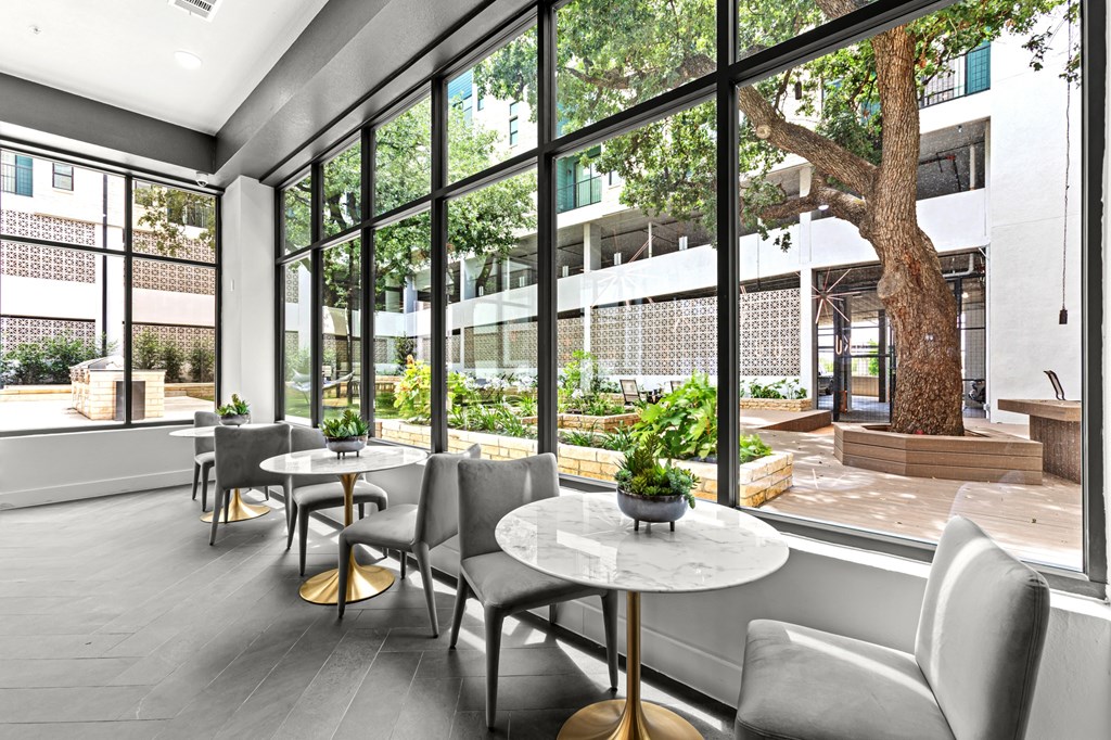 A room with grey chairs and a table with a plant on it.