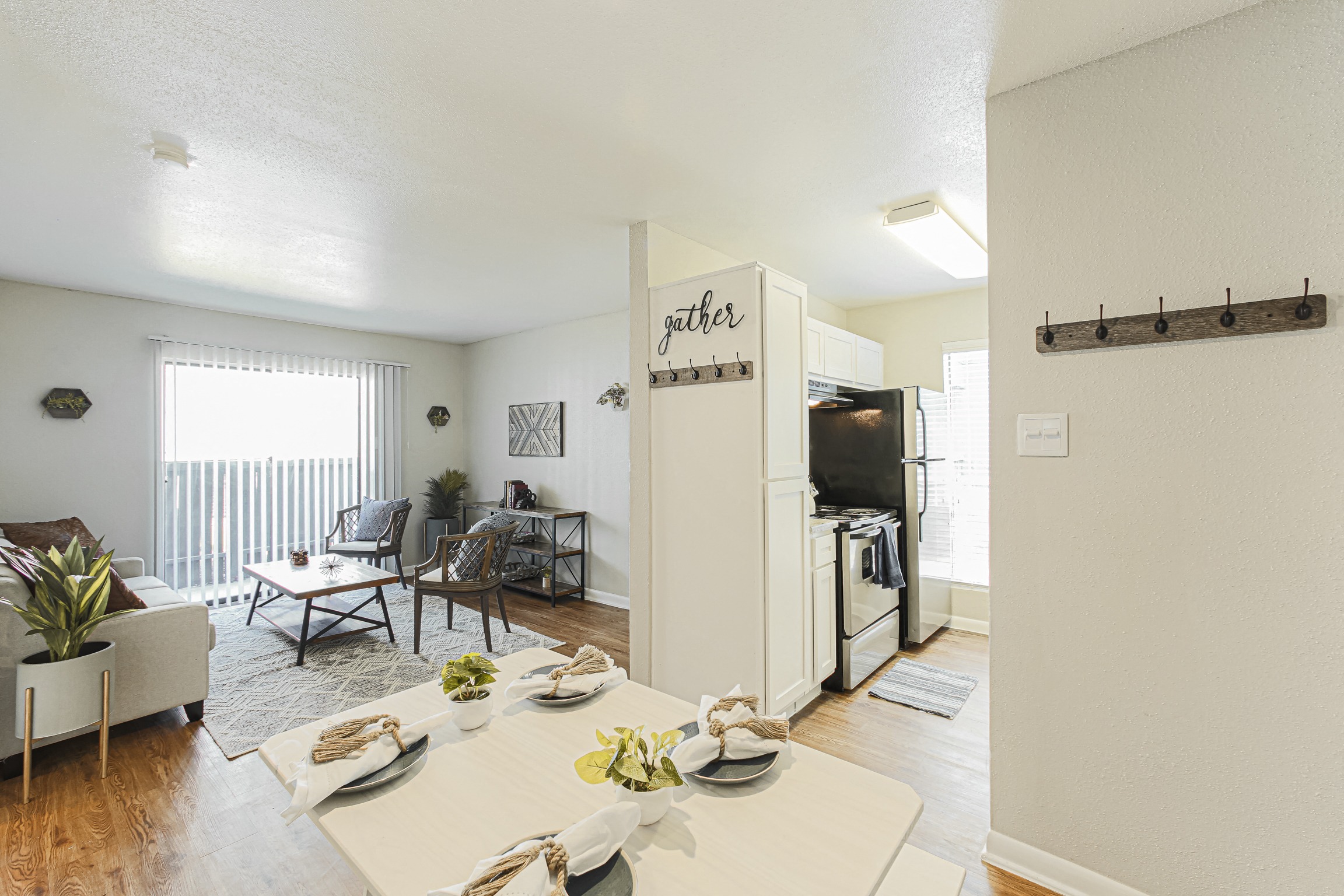 an open living room and dining room with a table and chairs and a kitchen