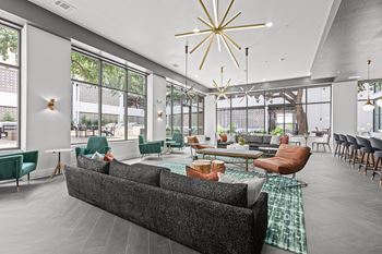 A modern living room with a grey sofa and green chairs.