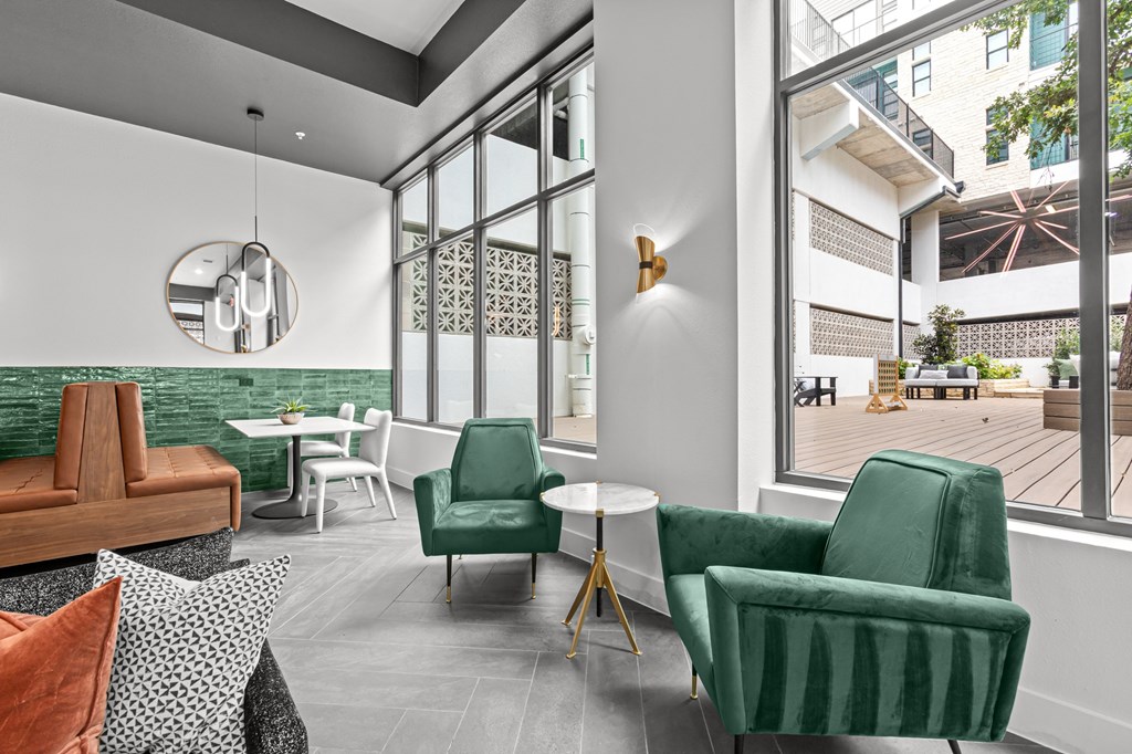 A living room with a green chair and a white table.