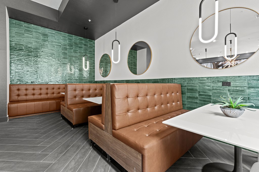 A modern dining area with a white table and brown booths.