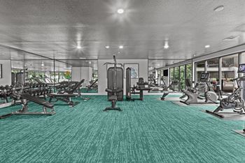 A gym with a variety of equipment including treadmills, weights, and exercise machines.