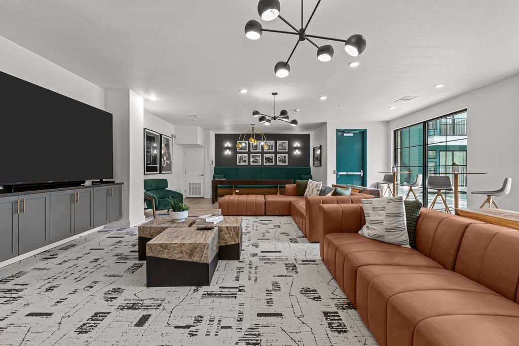 A living room with a brown sofa and a black and white floor.