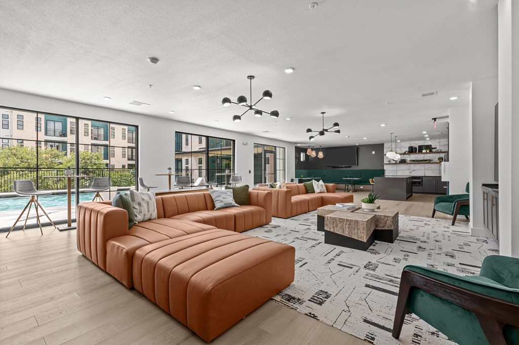 A living room with a pool table and a large orange sofa.