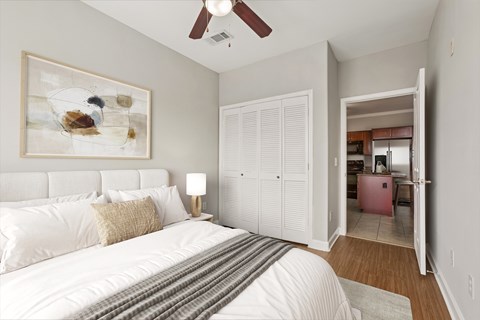 A bedroom with a large bed and a painting on the wall.
