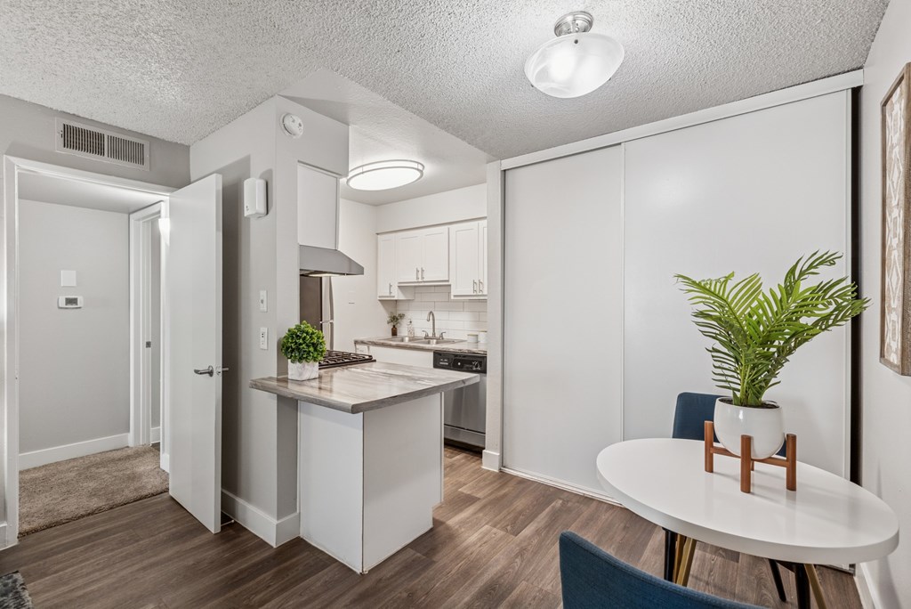 A kitchen with a table and chairs.