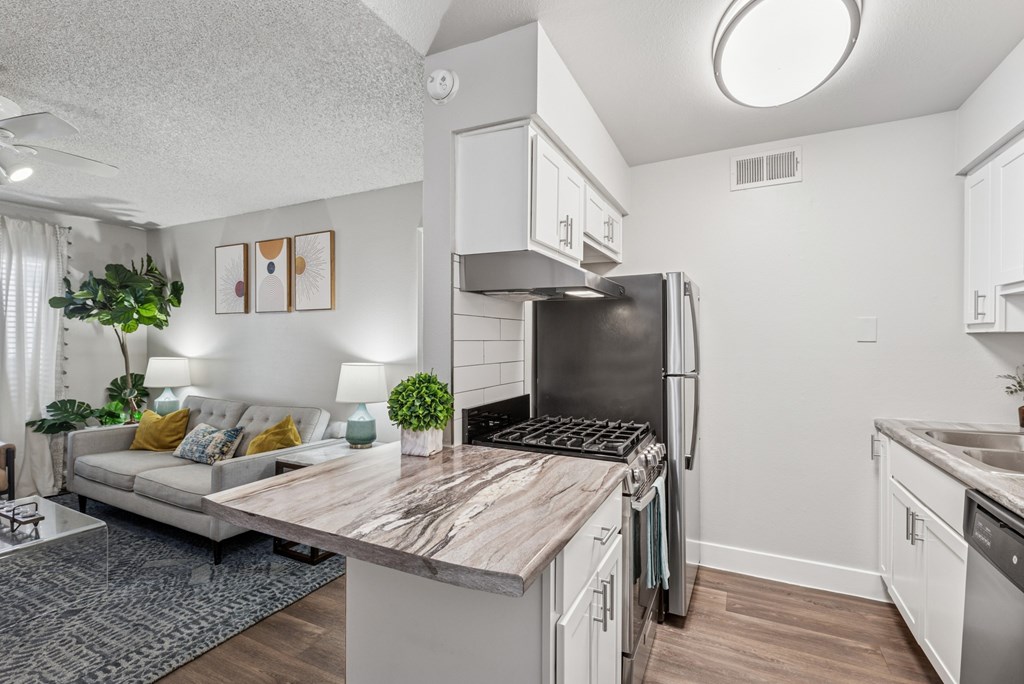 A modern kitchen with a refrigerator, stove, and sink.