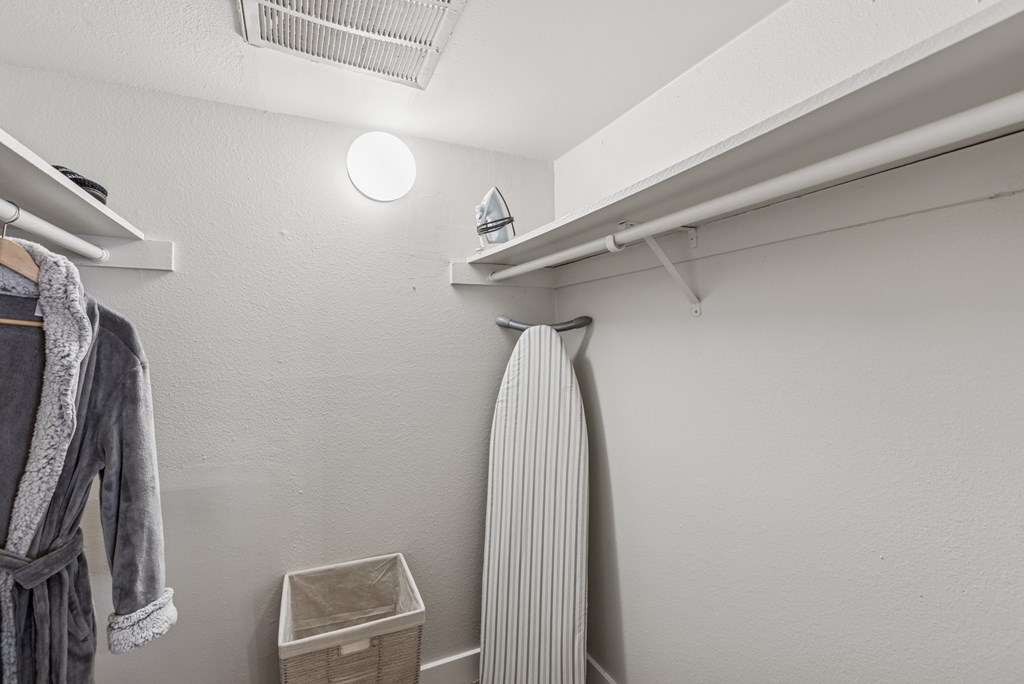 A white bathroom with a striped towel hanging on the rack.