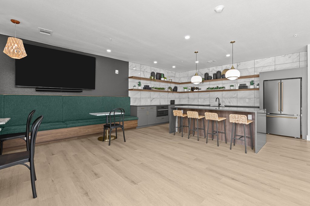 A modern kitchen with a bar area and a television.