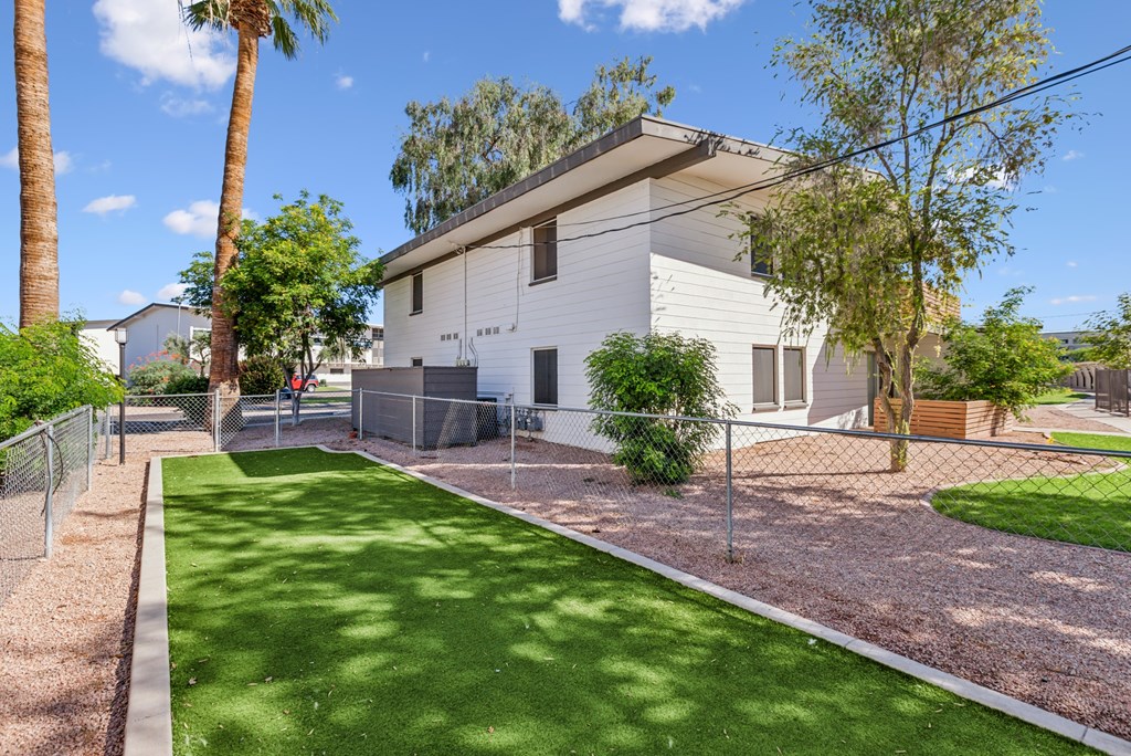 A white house with a green lawn in front.