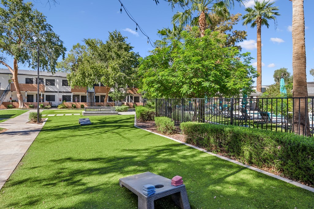 A park with a bench and a fence.