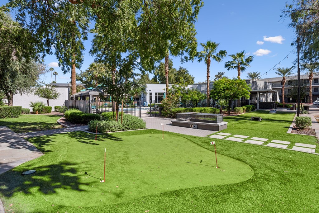A green lawn with a white sign and a fence in the background.