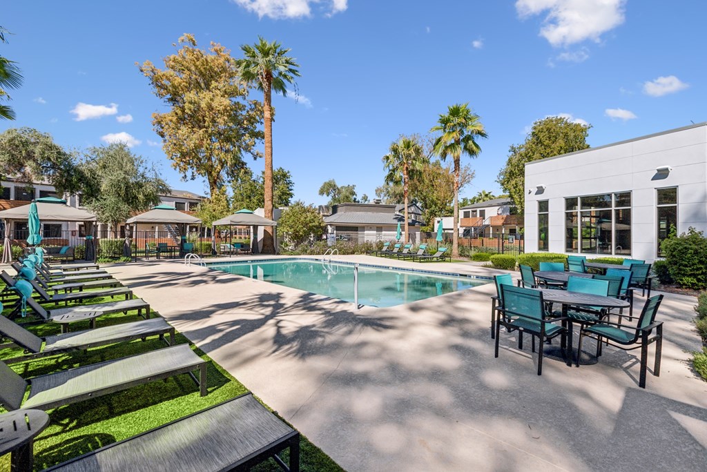 A pool area with sun loungers and a table.