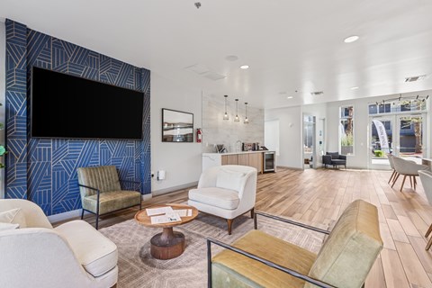 A living room with a white couch and a blue wallpapered wall.