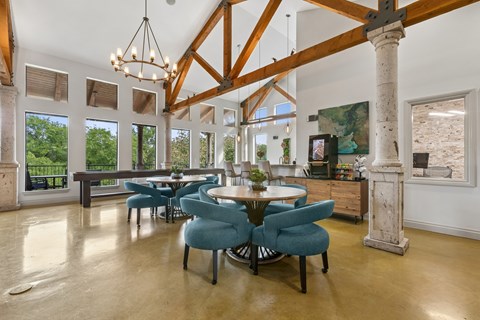 A large dining room with a table surrounded by chairs.