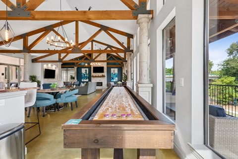 A pool table is in the middle of a room with a wooden ceiling.