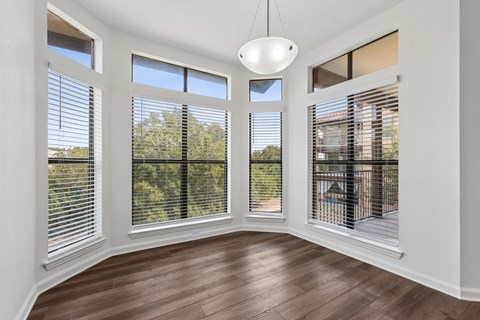 A room with a large window and a wooden floor.