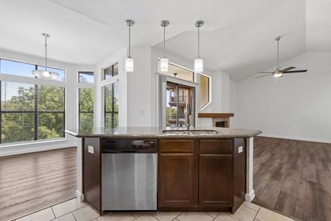 A kitchen with a large island and a stainless steel dishwasher.