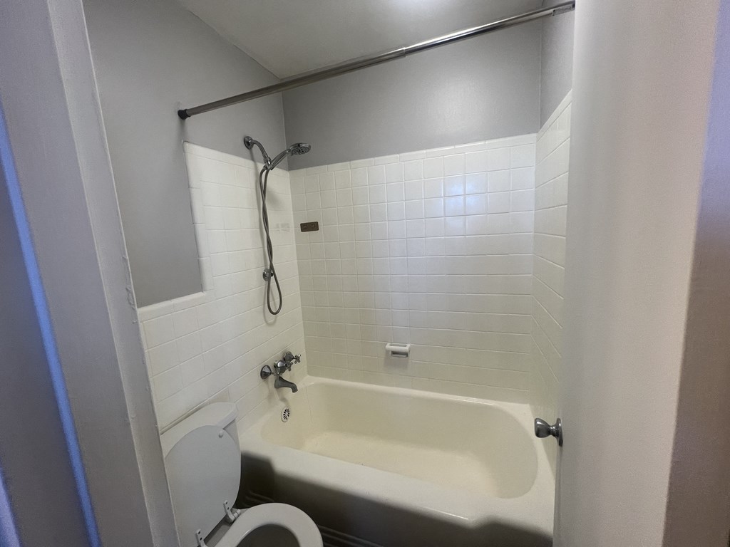 a small bathroom with a tub and a toilet