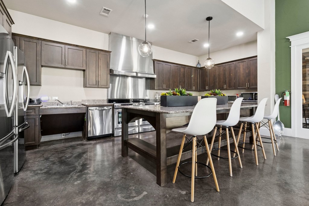 A modern kitchen with a large island and stainless steel appliances.