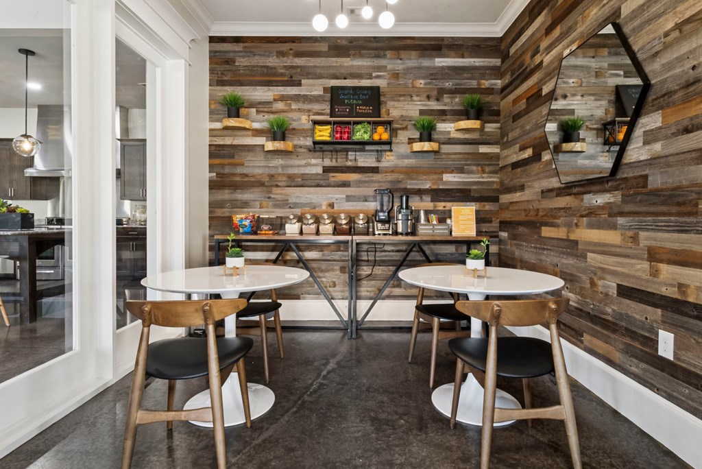 A modern dining area with wooden walls and tables set for two.
