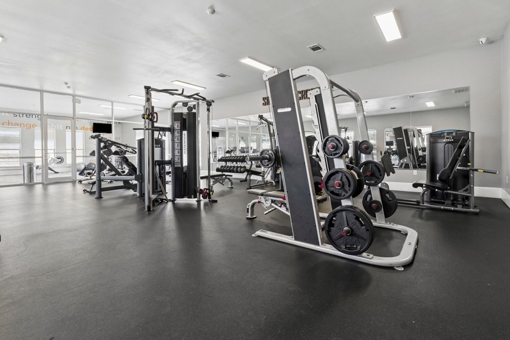 A gym with a variety of equipment including a leg press machine.