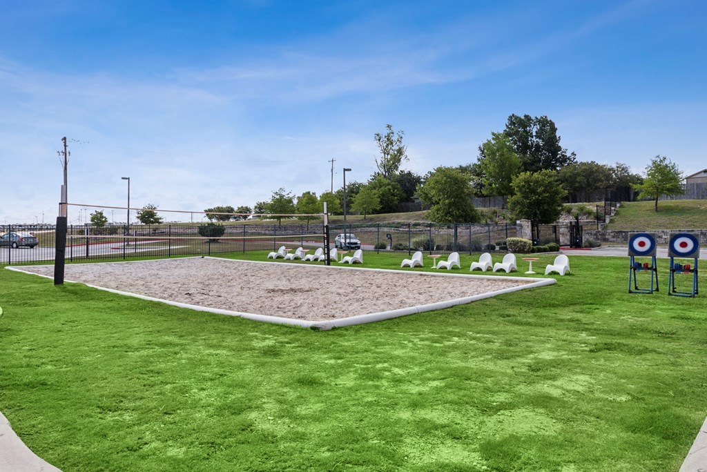 A grassy field with a target range and a fence.