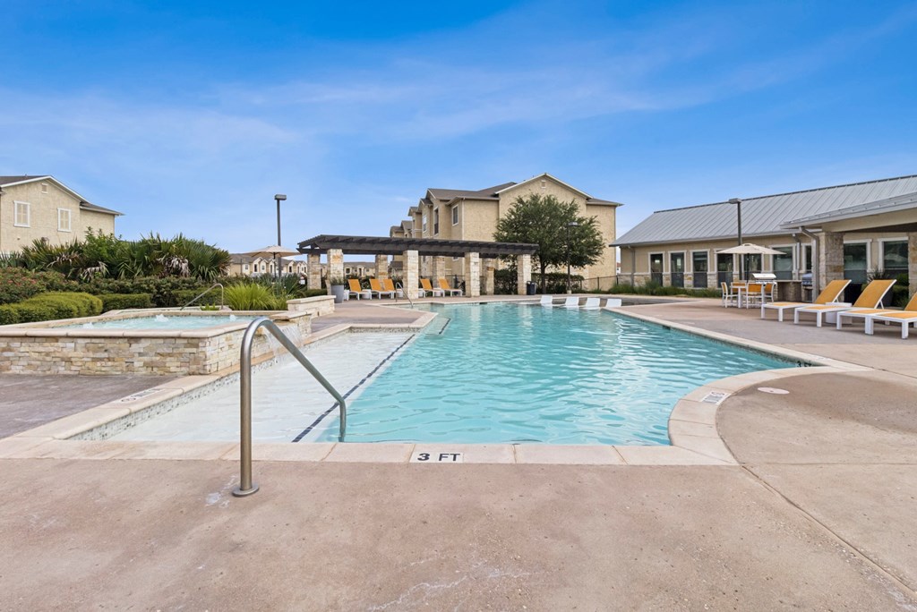A swimming pool with a metal ladder and a building in the background.