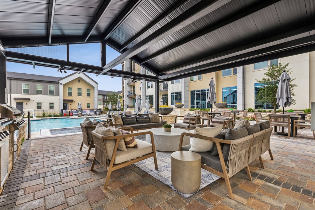 A patio with a table and chairs under a roof.