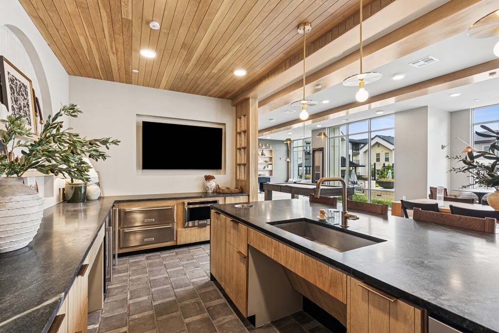 A modern kitchen with a wooden ceiling and a large island.