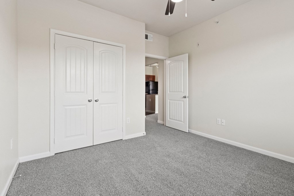 A room with white doors and a grey carpet.