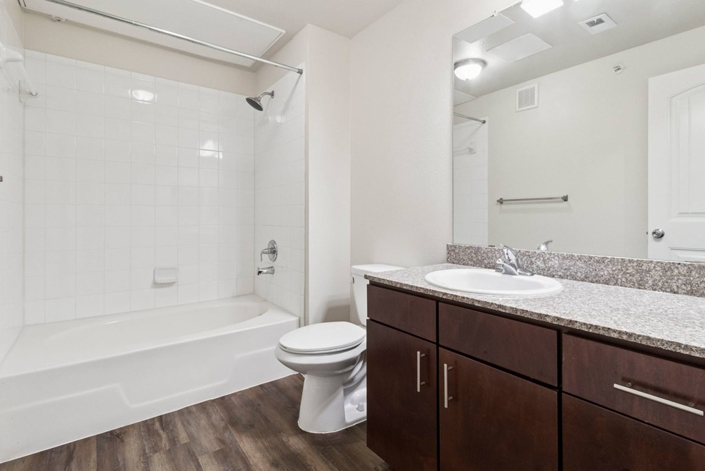 A white toilet sits next to a bathtub in a bathroom.