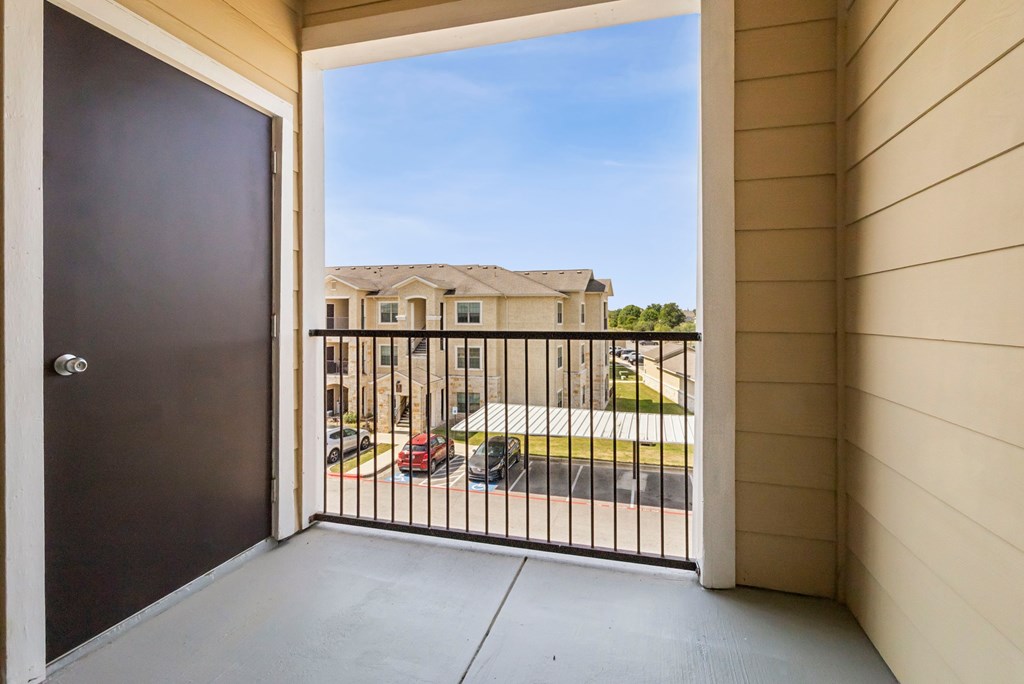 A view from a balcony looking out at a residential street.
