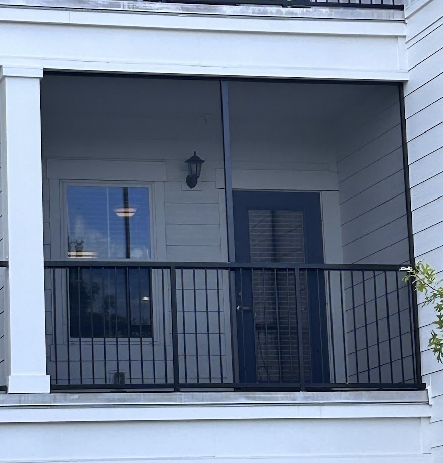 A balcony with a black railing and a window.