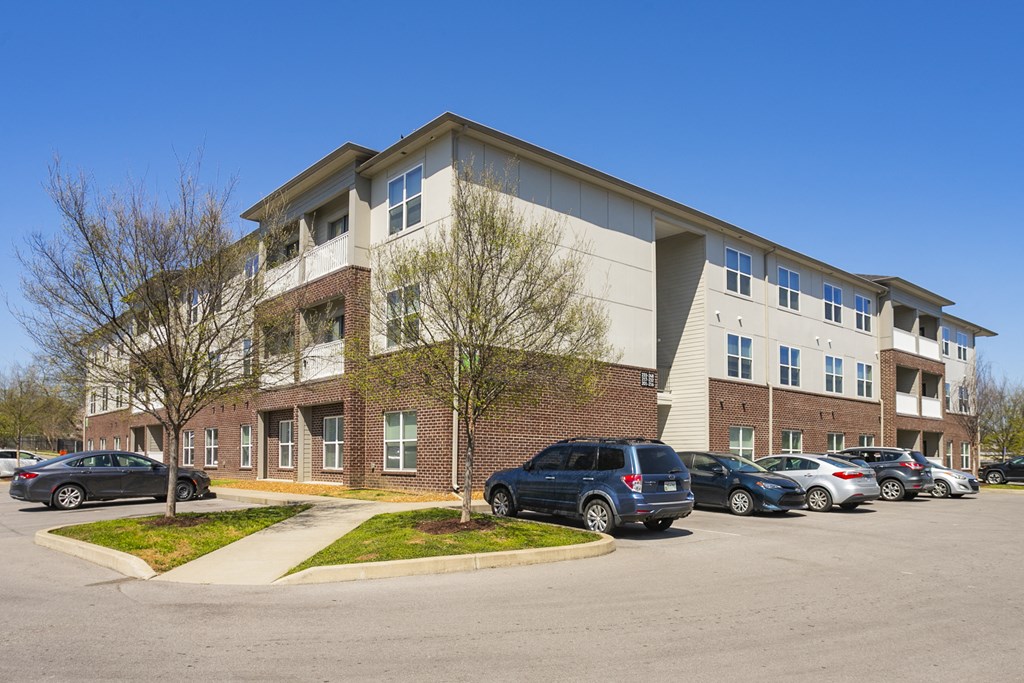a large apartment building with a parking lot in front of it