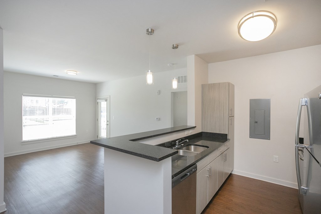 a kitchen with white walls and a black counter top