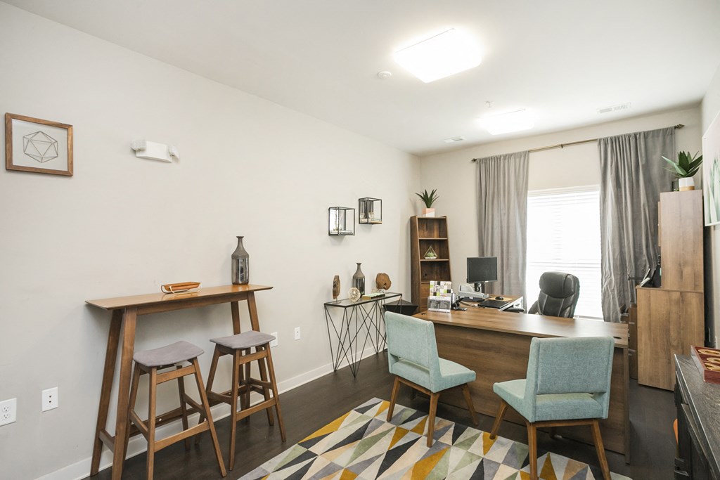 a home office with a desk and stools in front of a window