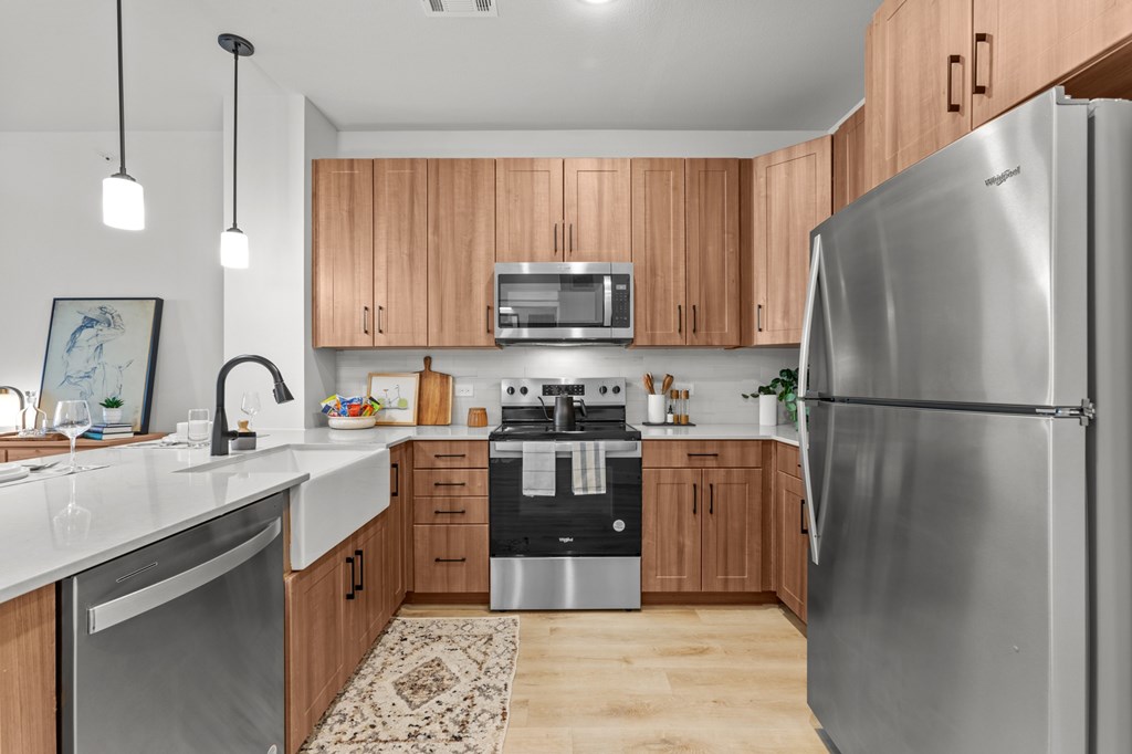 A modern kitchen with wooden cabinets and stainless steel appliances.