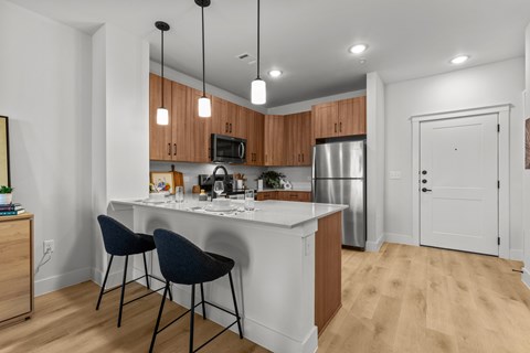 A kitchen with a white counter and wooden cabinets.